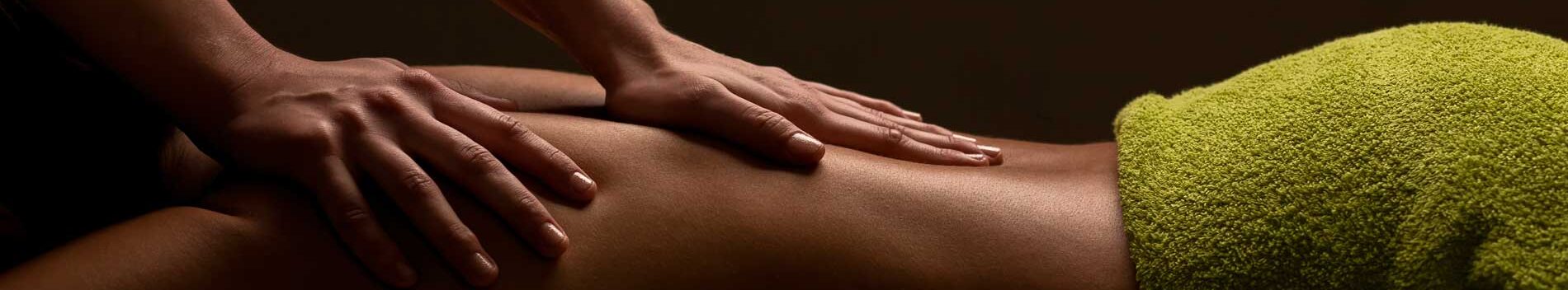 A pair of hands gently massaging a woman's bare back